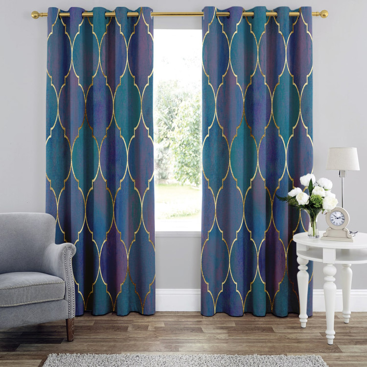 پرده پانچی مخمل لازار با طرح هندسی مراکشی در رنگهای آبی فیروزهای و لاجوردی با حاشیههای طلایی در یک چیدمان شیک.