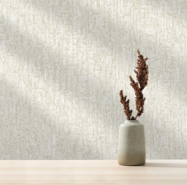 نمای نزدیک از کاغذدیواری کرم بافتدار با رگههای طلایی شایندار و پسزمینه پتینه گرم