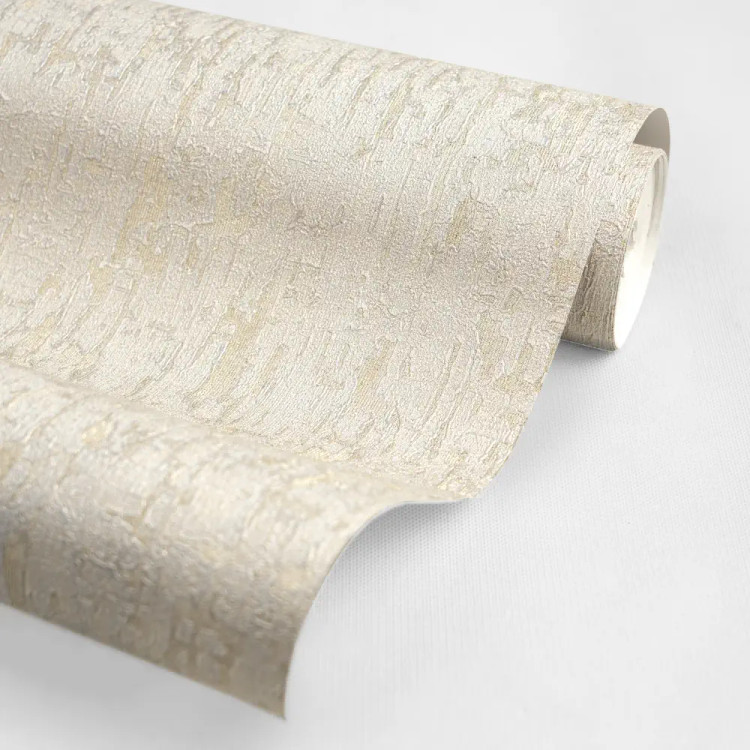 نمای نزدیک از کاغذدیواری کرم بافتدار با رگههای طلایی شایندار و پسزمینه پتینه گرم